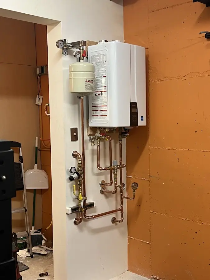 Plumbing technician inspecting water heater connections in Hoquiam